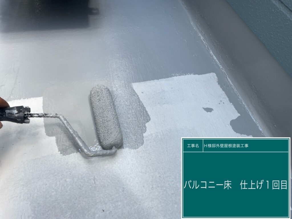 ベランダに仕上げ材のトップコートの1回目を塗布します。